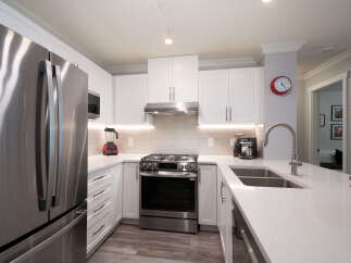 Experience modern living in this stunning kitchen featuring sleek stainless steel appliances, including a French door refrigerator and a gas range.