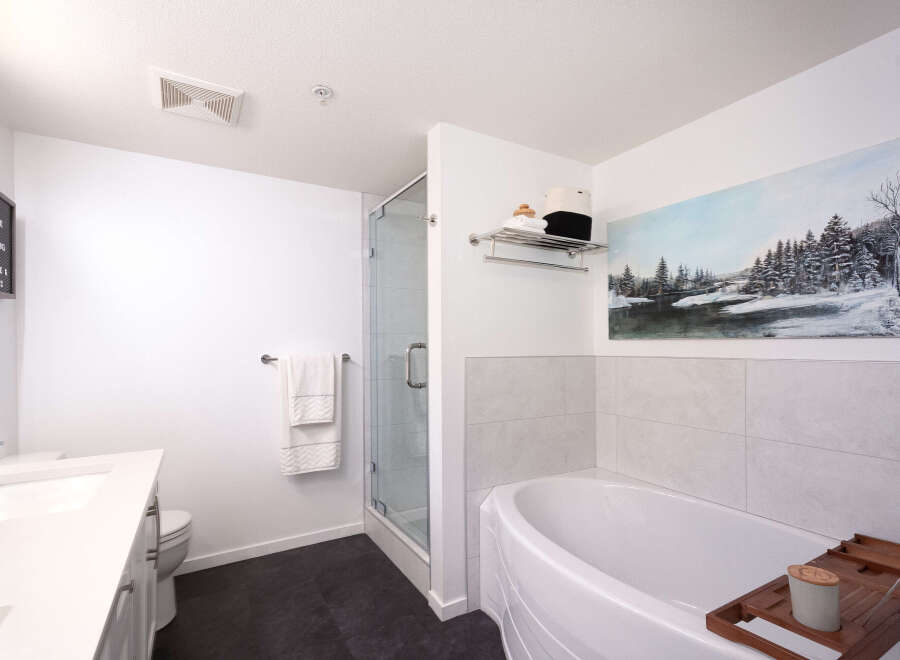 Experience modern comfort in this beautifully appointed bathroom, featuring a sleek vanity, a glass-enclosed shower, and a luxurious soaking tub perfect for unwinding.