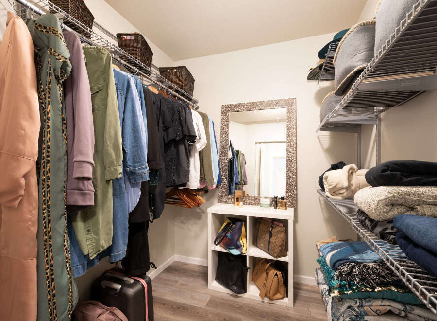 Discover ample storage in this walk-in closet, featuring a well-organized shelving system and hanging racks.