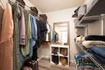 Discover ample storage in this walk-in closet, featuring a well-organized shelving system and hanging racks.