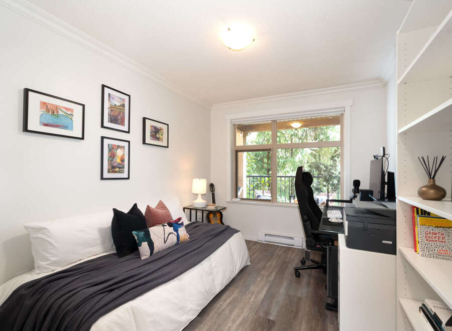 Discover this versatile room, perfect for a home office or guest bedroom, featuring a comfortable bed adorned with stylish pillows and a dark grey throw.