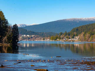 Discover serene waterfront living with this stunning property offering breathtaking views of the lake and snow-capped mountains.