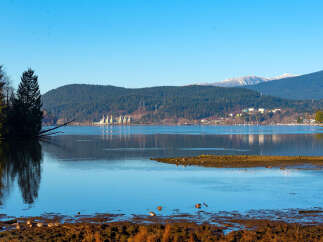 Experience serene waterfront living with this stunning property offering breathtaking views of the tranquil bay and majestic mountains.