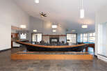 Experience unique living in this spacious common area, featuring a striking canoe centerpiece and a cozy fireplace.