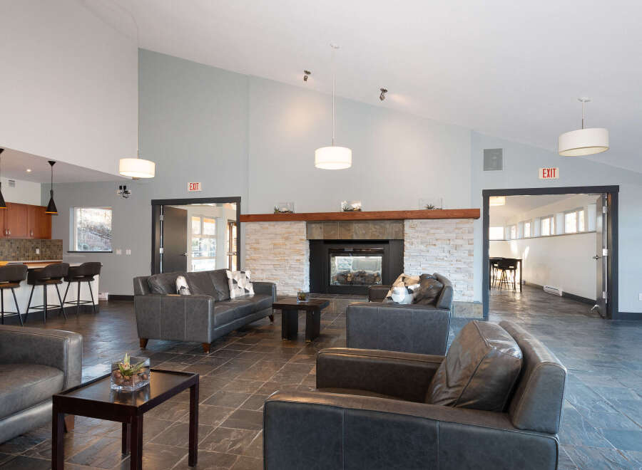 Experience modern comfort in this spacious lounge area, featuring plush leather sofas and a striking stone fireplace as the centerpiece.