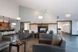 Experience modern comfort in this spacious lounge area, featuring plush leather sofas and a striking stone fireplace as the centerpiece.
