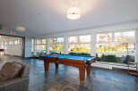 Enjoy leisure time in this spacious game room featuring a professional-grade pool table and comfortable seating.