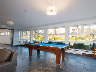 Enjoy leisure time in this spacious game room featuring a professional-grade pool table and comfortable seating.