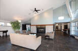 Experience modern living in this spacious lounge area featuring a striking stone fireplace and comfortable seating.