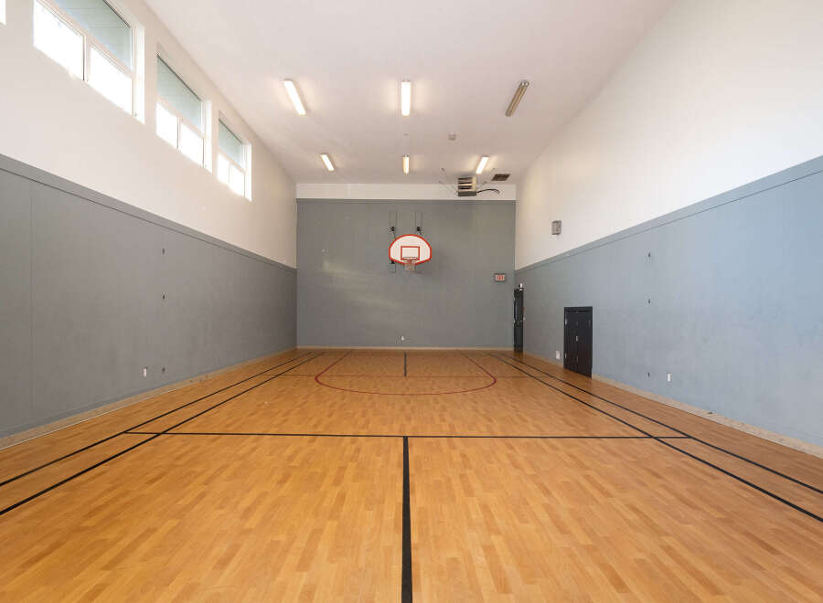 Step onto the polished hardwood court of this indoor gymnasium, perfect for basketball or other recreational activities.