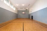 Step onto the polished hardwood court of this indoor gymnasium, perfect for basketball or other recreational activities.