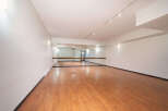 This spacious dance studio features a polished wooden floor, perfect for all types of movement.