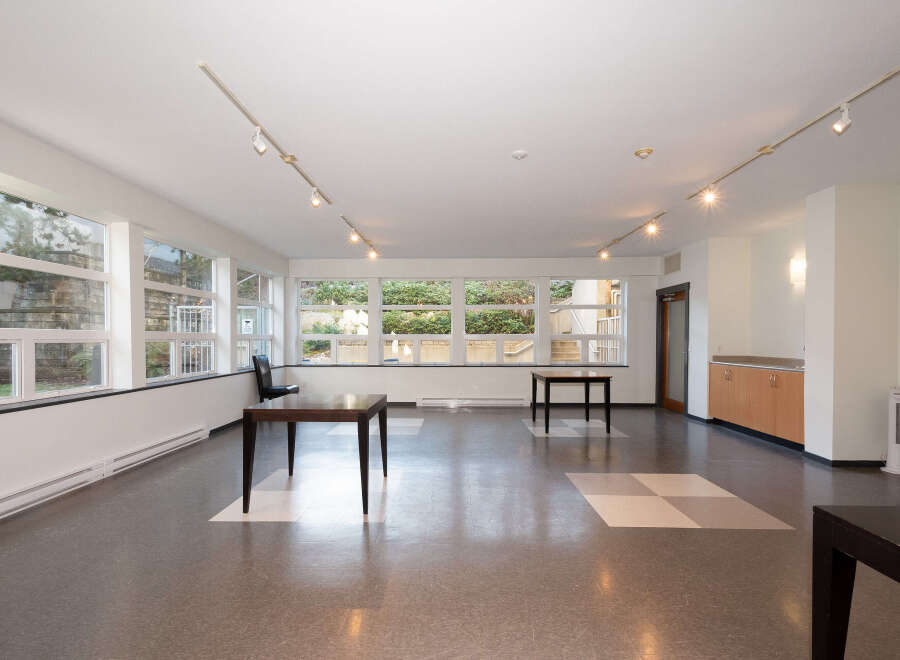 This spacious room features large windows offering abundant natural light and views of the outdoors.