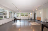 This spacious room features large windows offering abundant natural light and views of the outdoors.