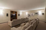 Experience cinematic bliss in this dedicated home theater, featuring plush tiered seating arranged for optimal viewing.