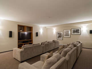 Experience cinematic bliss in this dedicated home theater, featuring plush tiered seating arranged for optimal viewing.