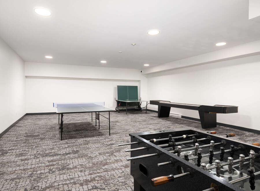 Enjoy endless entertainment in this spacious game room, featuring a ping pong table, foosball table, and shuffleboard.