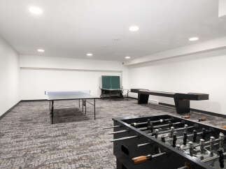 Enjoy endless entertainment in this spacious game room, featuring a ping pong table, foosball table, and shuffleboard.