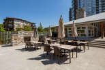 Enjoy outdoor living with this spacious patio area, featuring multiple dining sets and umbrellas perfect for al fresco meals.