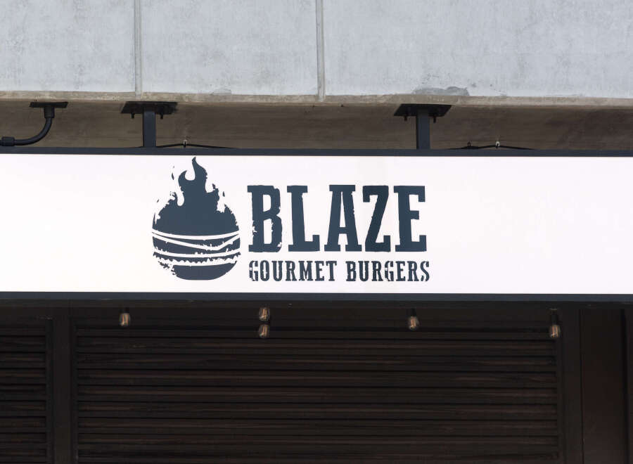 Discover a prime commercial space perfect for a restaurant or retail business, featuring prominent signage for 'Blaze Gourmet Burgers'.