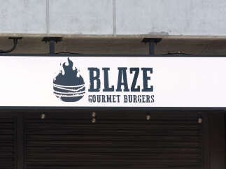 Discover a prime commercial space perfect for a restaurant or retail business, featuring prominent signage for 'Blaze Gourmet Burgers'.