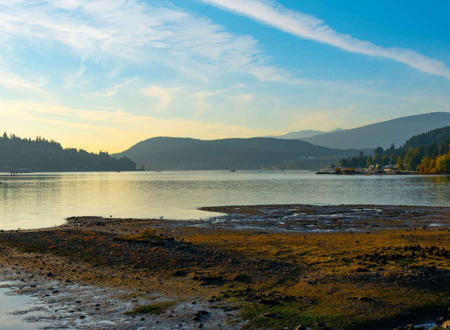 Experience serene waterfront living with this stunning property offering breathtaking views of the calm bay and distant mountains.