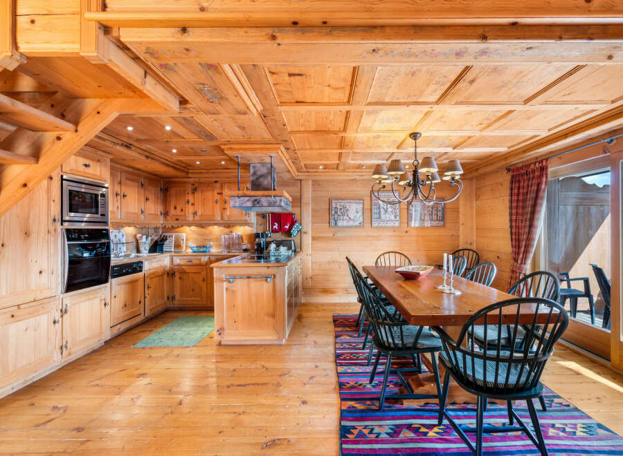 Experience rustic charm in this beautifully appointed wooden chalet kitchen and dining area.