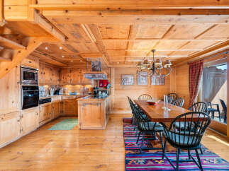 Experience rustic charm in this beautifully appointed wooden chalet kitchen and dining area.