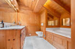 Experience rustic luxury in this charming bathroom, featuring warm wooden paneling throughout and a spacious bathtub perfect for relaxation.