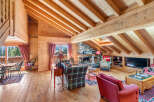 Experience rustic charm in this beautifully appointed living room, featuring a grand stone fireplace and exposed wooden beams that create a warm, inviting atmosphere.