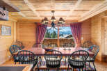 Experience rustic charm in this dining room, featuring a large wooden table surrounded by black Windsor chairs.
