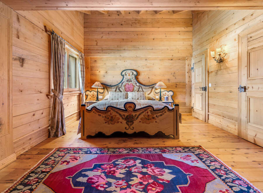 Experience rustic charm in this beautifully appointed bedroom, featuring warm, natural wood paneling throughout.