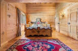 Experience rustic charm in this beautifully appointed bedroom, featuring warm, natural wood paneling throughout.