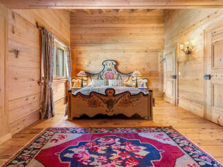 Experience rustic charm in this beautifully appointed bedroom, featuring warm, natural wood paneling throughout.