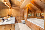 Experience rustic luxury in this charming wooden bathroom, featuring a spacious double vanity with marble countertops and elegant chrome fixtures.