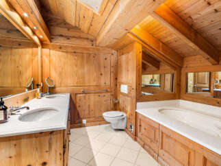 Experience rustic luxury in this charming wooden bathroom, featuring a spacious double vanity with marble countertops and elegant chrome fixtures.