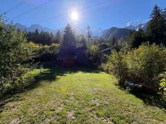 Experience the serene beauty of the Alps from this charming property, nestled amidst lush greenery and offering breathtaking mountain views.