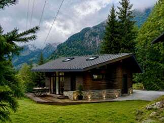 Experience serene mountain living in this charming wooden cabin nestled amidst lush greenery.