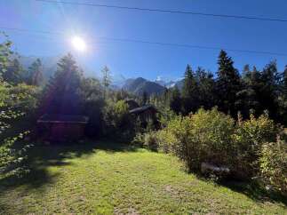 Nestled amidst lush greenery and towering trees, this property offers a serene mountain retreat.