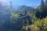 Nestled amidst lush greenery and towering trees, this charming property offers a serene mountain retreat.