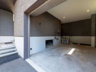 Discover modern living with this spacious garage featuring a sleek, textured exterior and a clean, concrete interior.