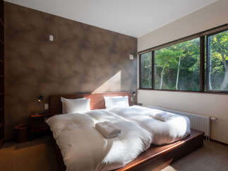 Experience serene comfort in this inviting bedroom, featuring two plush twin beds dressed in crisp white linens.