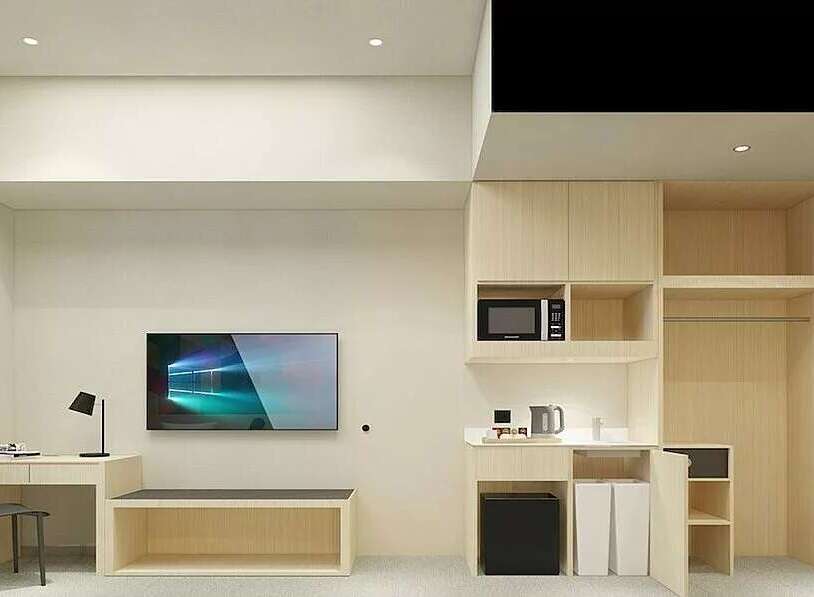 This modern studio apartment features a compact kitchenette with a microwave and kettle, perfect for preparing simple meals.