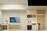 This modern studio apartment features a compact kitchenette with a microwave and kettle, perfect for preparing simple meals.