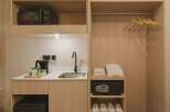 This hotel room offers a convenient kitchenette area complete with a microwave, sink, and electric kettle, perfect for preparing simple meals or hot beverages.