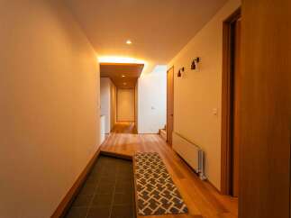 Step into this inviting hallway featuring warm wooden floors and a stylish runner rug.