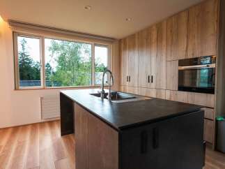 Experience modern living in this stunning kitchen featuring a sleek island with a built-in sink and faucet.