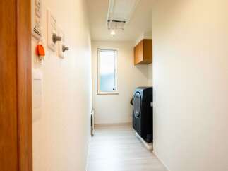 Discover this modern laundry room featuring a sleek black washing machine and convenient wall-mounted storage.