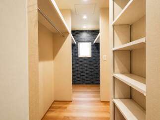 Discover ample storage solutions in this well-organized walk-in closet, featuring multiple shelves and a convenient hanging rod.