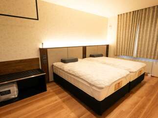 Experience comfort and style in this hotel room featuring two twin beds with plush mattresses and elegant headboards.